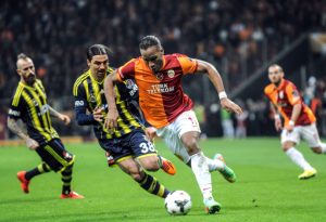 Galatasaray's Ivorian forward Didier Drogba (R) vies with Fenerbahce's Turkish midfielder Mehmet Topuz (L) during the Turkish Super League football match between Fenerbahce and Galatasaray, at Turk Telekom Arena in Istanbul, on April 6, 2014. AFP PHOTO/BULENT KILIC