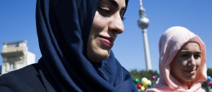 BERLIN, GERMANY - SEPTEMBER 01: Two muslim women pass on the event "About Berlin - religions make history" of historical significance as the broadcast tower at Alexanderplatz is visible behind 1, 2012 in Berlin, Germany. The event is part of the events ahead of Berlin's 775th anniversary, which the city will mark with a celebration scheduled for the end of October. (Photo by Carsten Koall/Getty Images)