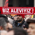 A protester holds a banner reading „we are alevi” as he and many others wait to hear the decision of the court in front of a courthouse in Ankara